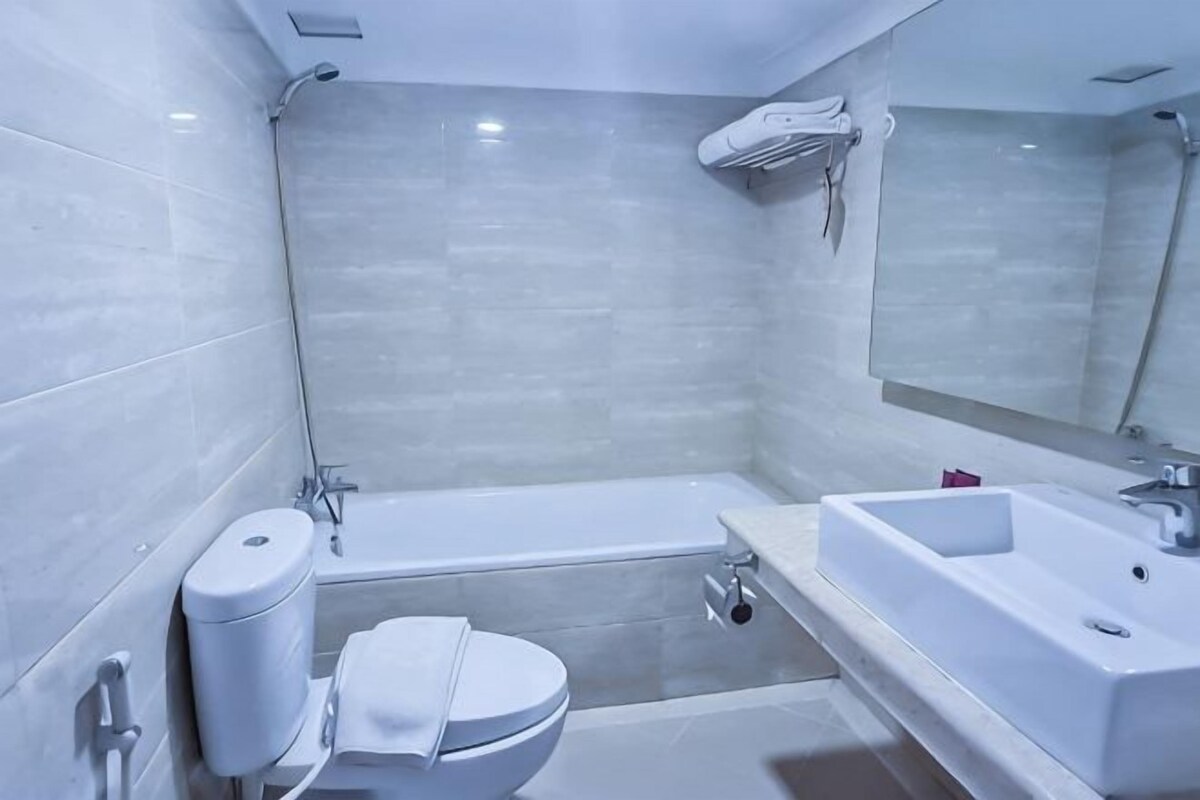 A modern bathroom with a toilet, bathtub, and sink.