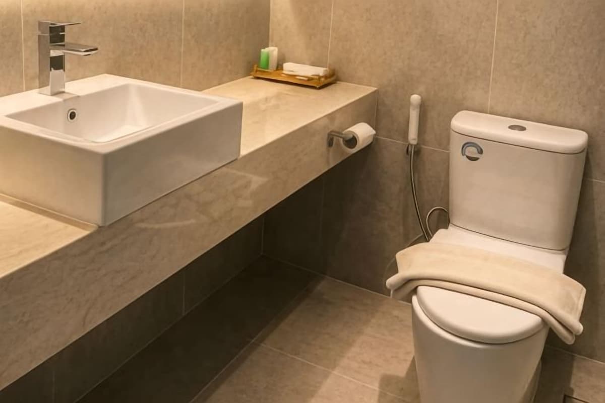 A bathroom with a white sink, toilet, and a towel rack.