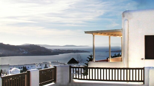 A balcony with a view of a body of water and distant land. - Loukas Pension (Mykonos)