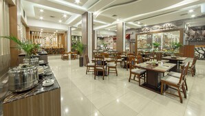 Un restaurant spacieux doté de plusieurs espaces de restauration, d’un buffet et de différents types d’aménagements pour s’asseoir.