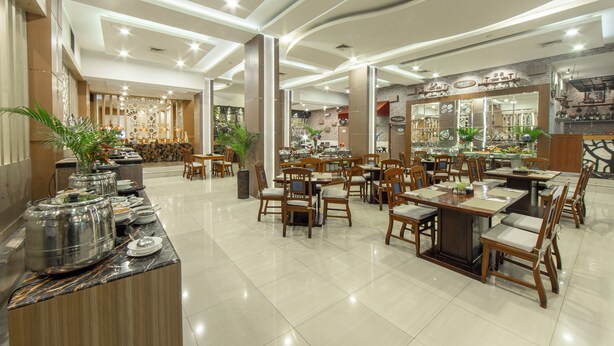 Un restaurante espacioso con varias zonas de comedor, una barra de buffet y diferentes opciones de asientos.
