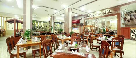 A spacious restaurant with wooden tables and chairs, a variety of dishes, and a modern interior design.