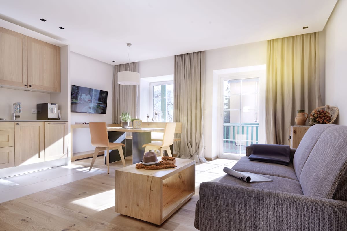 A modern living room with a sofa, coffee table, and dining area.