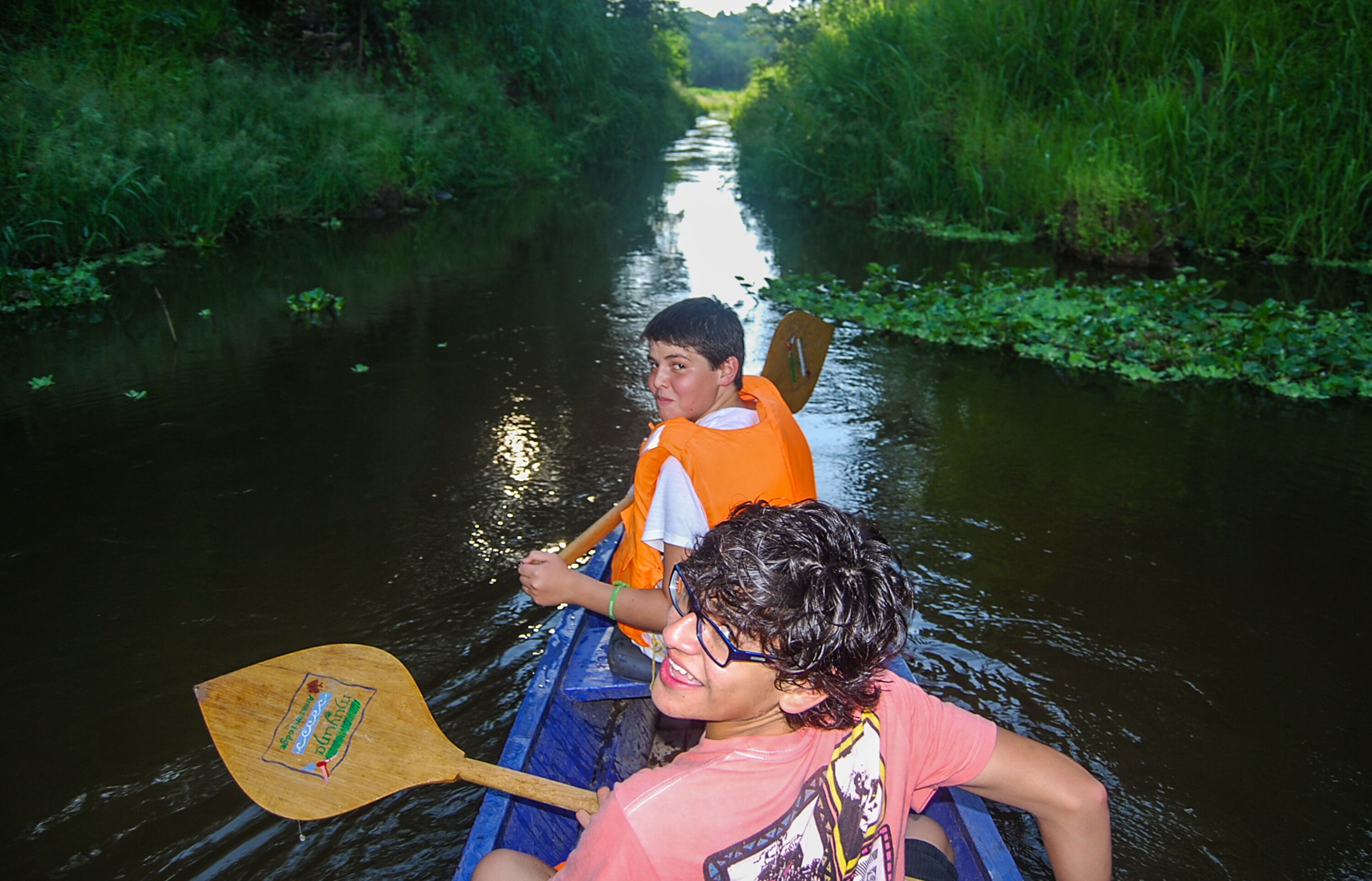 A narrow waterway with dense greenery on both sides.