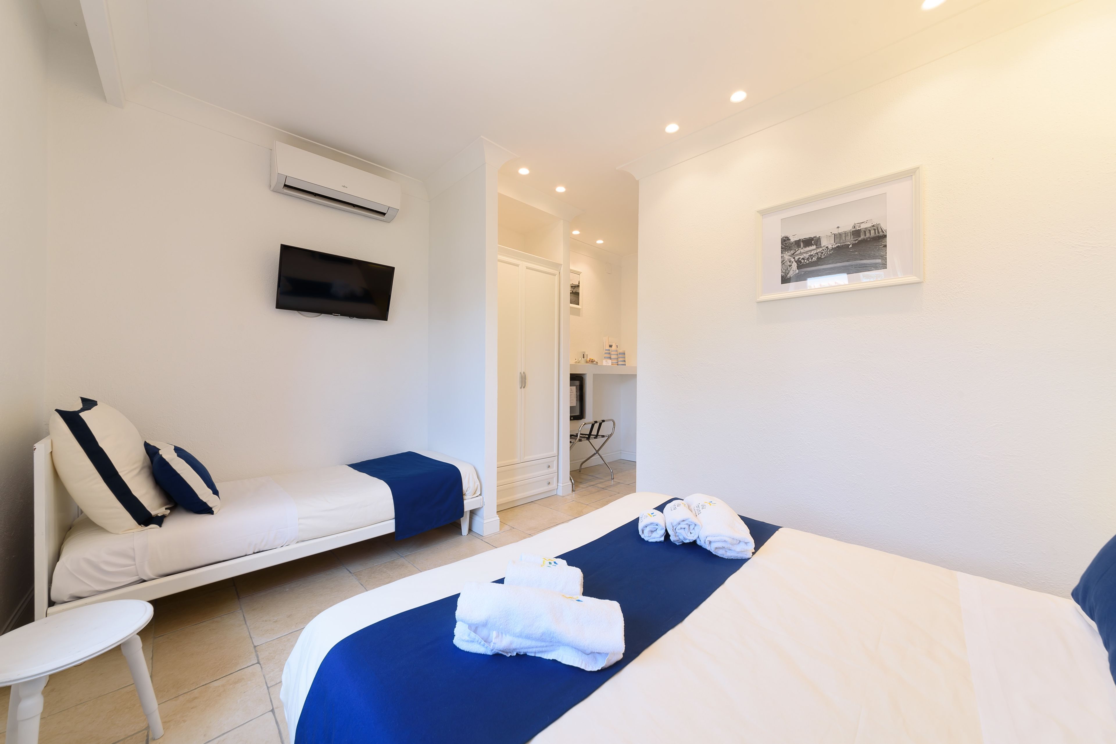 Une chambre d’hôtel équipée d’un lit, d’un canapé, d’une télévision et d’un appareil de climatisation.