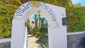 A white archway with "Villa Fortuna" written on it, leading to a gated entrance. - Villa Fortuna Holiday Resort (Ischia)