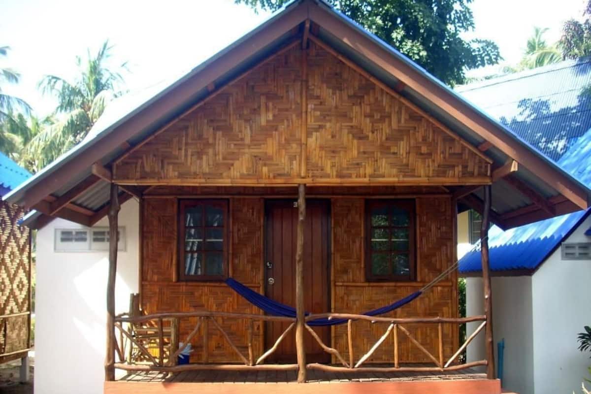 Una casa de madera con porche y una hamaca.