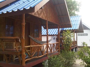 A wooden house with a porch, a hammock, and a large plant. - Coco Garden Resort (Ko Pha-ngan)