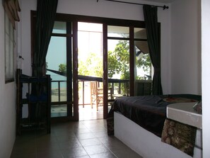 A room with a bed, a desk, and a view of the outside. - Coco Garden Resort (Ko Pha-ngan)
