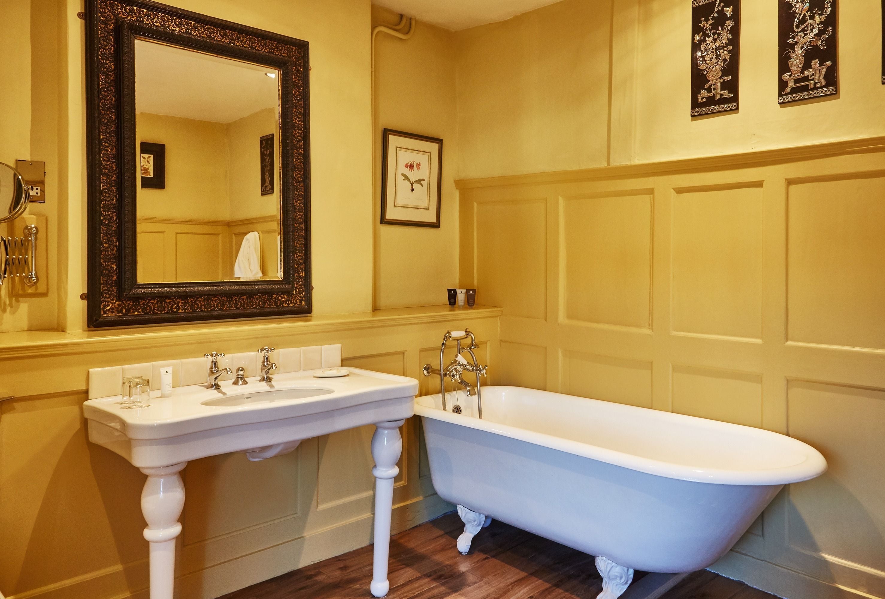A classic bathroom with a freestanding bathtub, a large mirror, and a white sink.