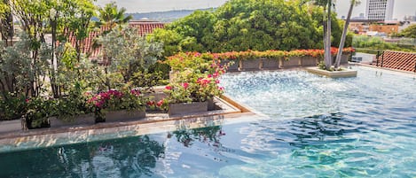 Outdoor pool, open 10:00 AM to 8:00 PM, pool umbrellas