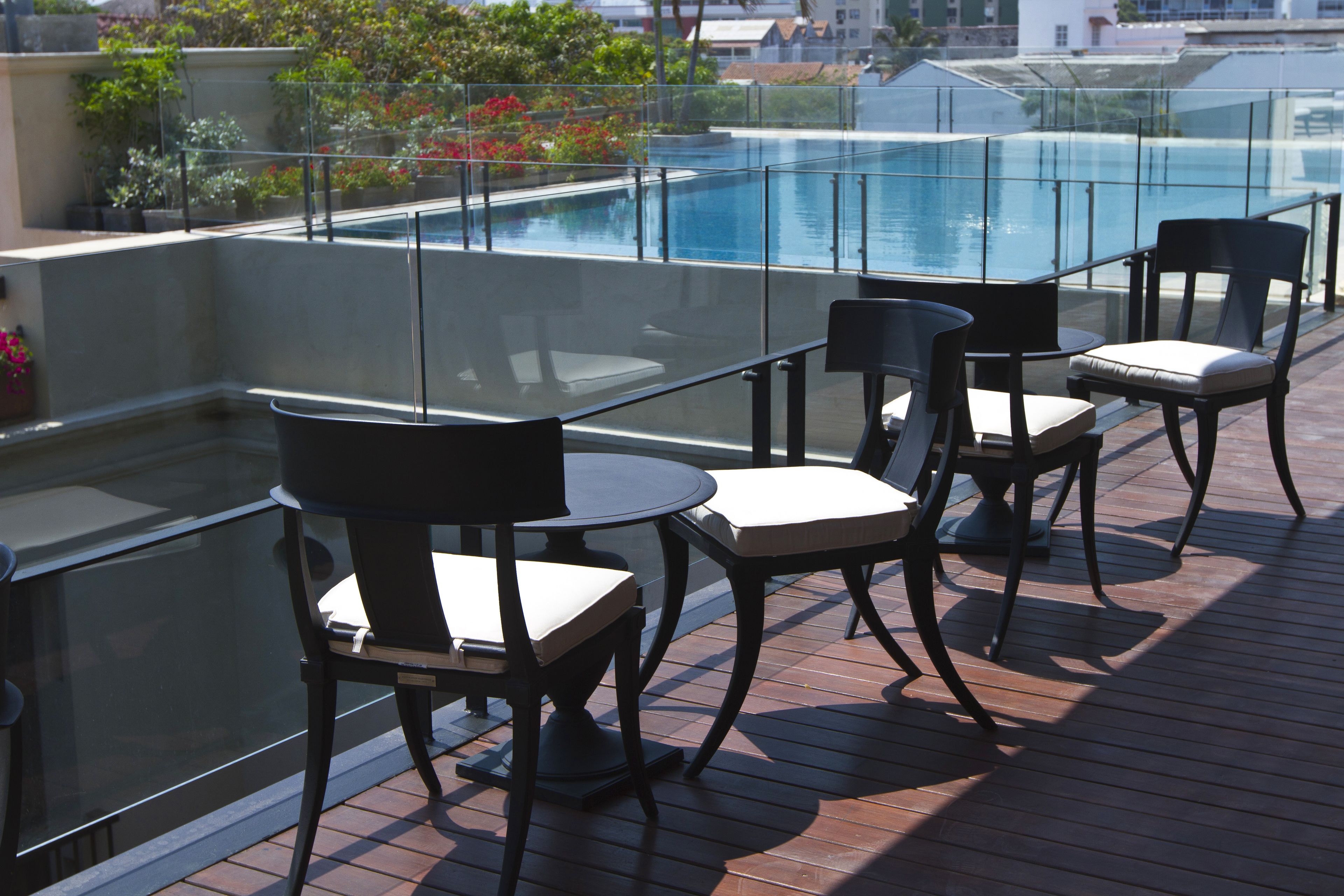 Terraza en la azotea con barandilla de vidrio, piscina y mobiliario de exterior.