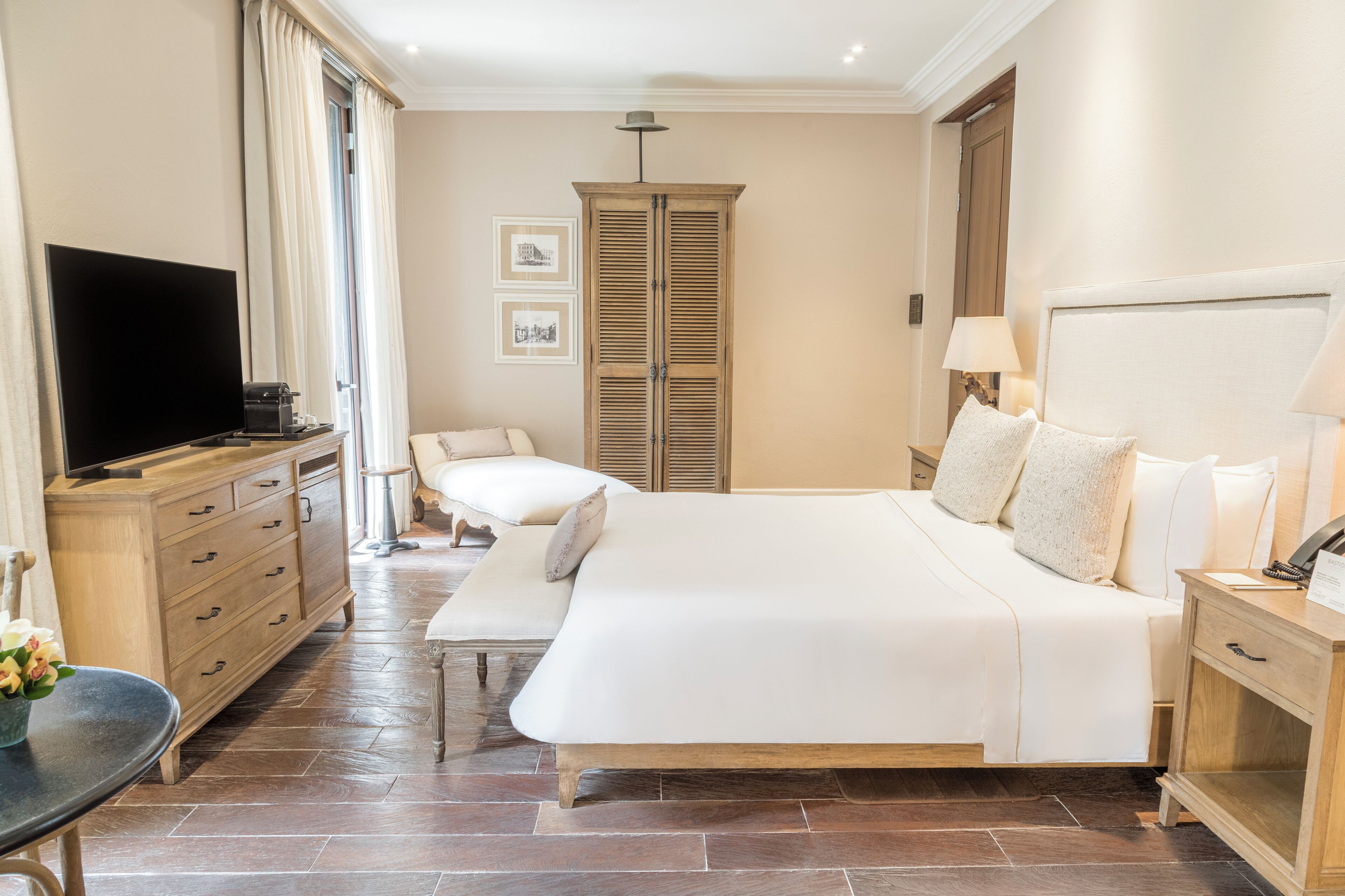 Un dormitorio espacioso con una cama grande, mesitas de noche, televisión y armario.