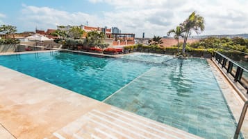 Una piscina al aire libre, sombrillas