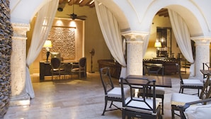 Un espace intérieur spacieux comprenant une table à manger et des chaises, un canapé et une lampe.