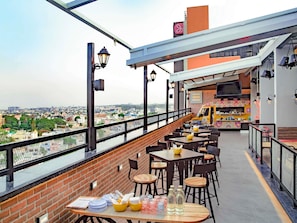 A rooftop restaurant with outdoor seating, a view of the city, and a sign for 'Soup of the Day Whiskey'. - ibis Bengaluru City Centre Hotel (Bengaluru)