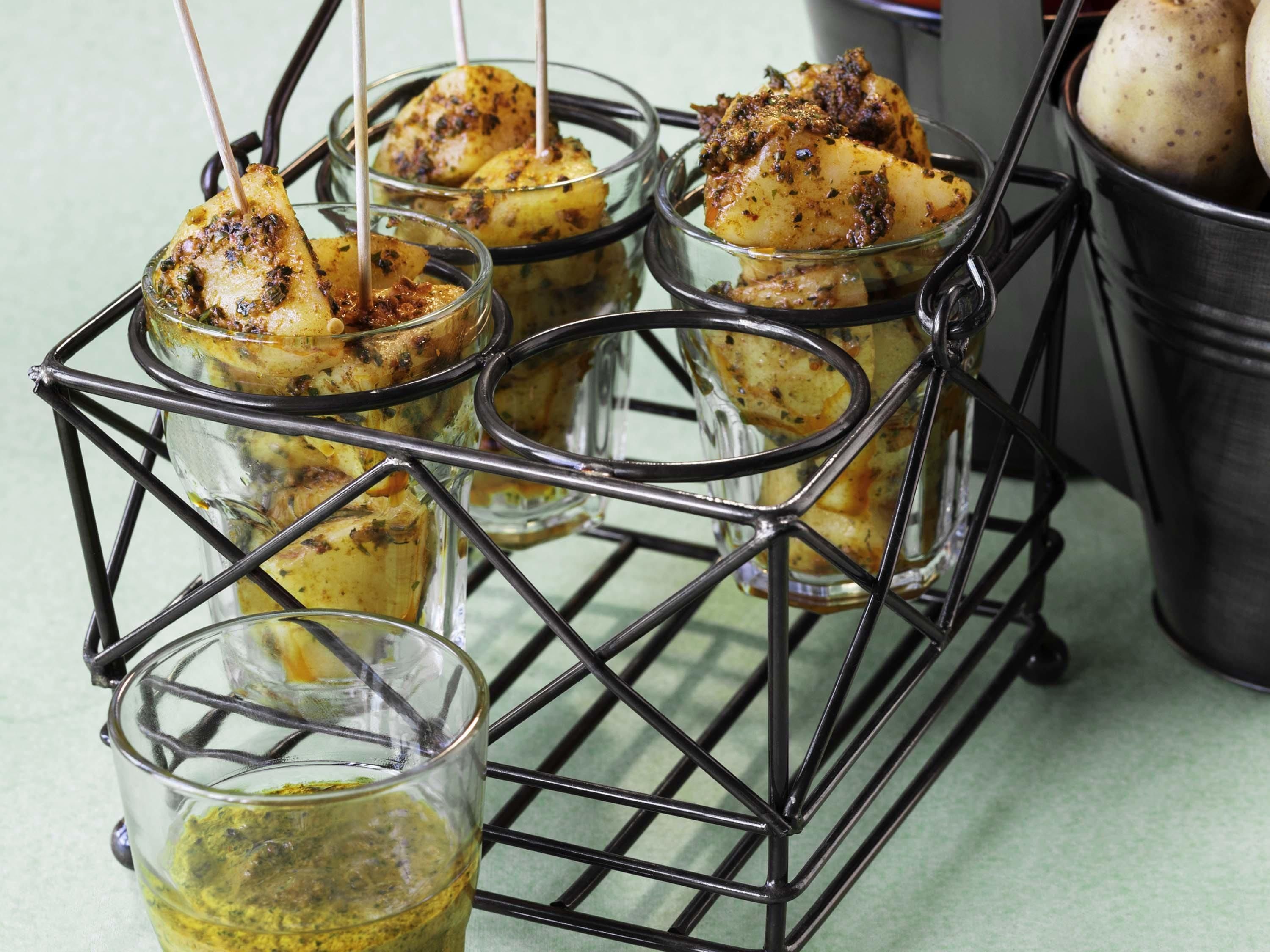 A metal rack holding glasses with food items.