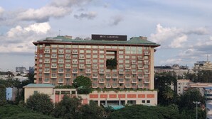 Un edificio de varios pisos con balcones, techo verde y un cartel que dice "ITC Gardenia".
