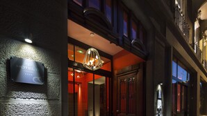 Een hotelentree met een bord, een kroonluchter en een grote houten deur.