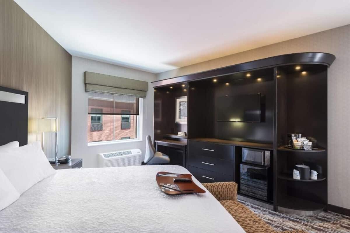 Ein Hotelzimmer mit Bett, Schreibtisch, Fernseher und Kamin.