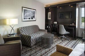 Relax in a comfortable space with a sofa, armchair, and coffee table, perfect for unwinding and working.