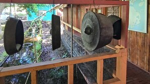 Una estructura rústica de madera con techo metálico, una fuente de agua y un mapa en la pared.