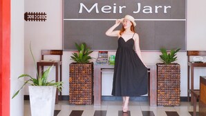 A woman in a black dress standing in front of a reception desk with a sign reading "Meir Jarr". - YouDee Hotel Patong (formerly Meir Jarr Hotel) (Patong)