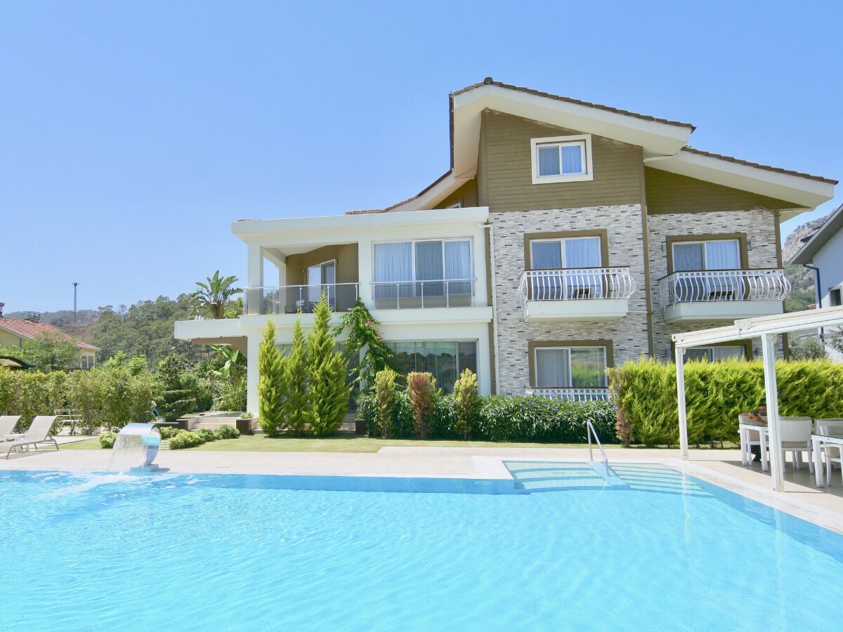 A two-story building with a swimming pool in front.