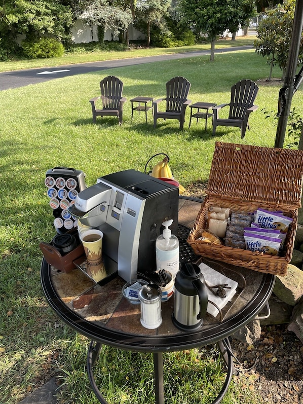 A table with a coffee machine, a basket of snacks, and a cup of coffee. - Boulevard Motel (Marmora)