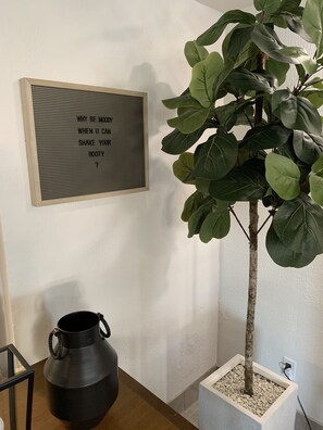 A potted plant with a sign on the wall beside it. - The Caretta  (Myrtle Beach)