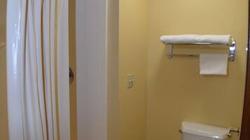 A bathroom with a shower, toilet, and towel rack.