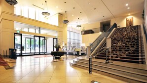 A spacious lobby with a staircase, a reception desk, and a large window. - Hotel Lifort Sapporo (Sapporo)