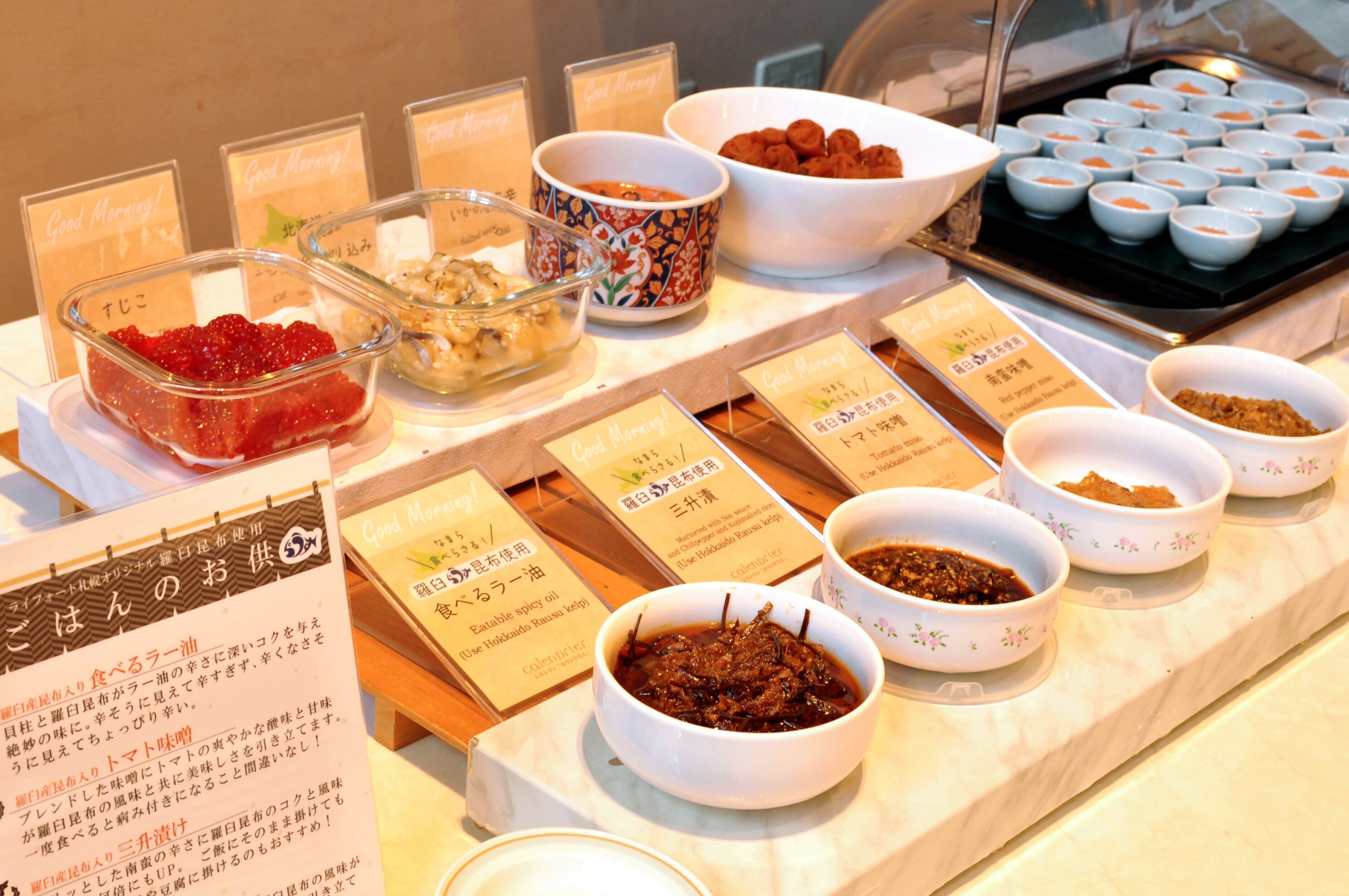 Un bufé con diversos platos y etiquetas en japonés.