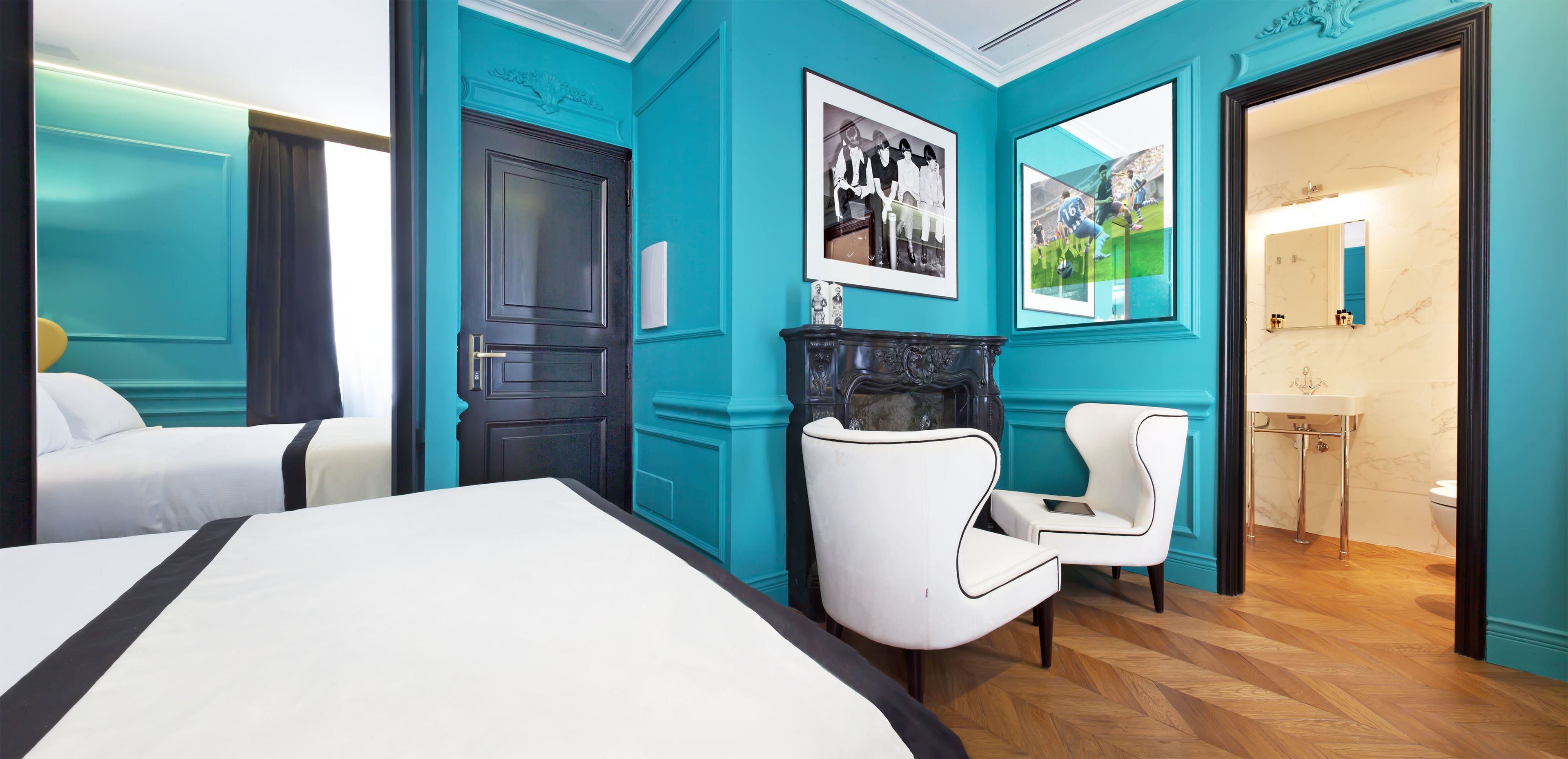 Ein Hotelzimmer mit Bett, einem Sessel, einem Kamin und einem durch eine geöffnete Tür einsehbaren Badezimmer.