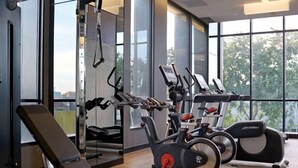 A gym with cardio machines, weightlifting equipment, and a bench. - Everbright (Surabaya)