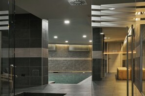 A modern hotel lobby with a glass partition, a pool area, and a private room sign. - Hotel Europa (Valtournenche)