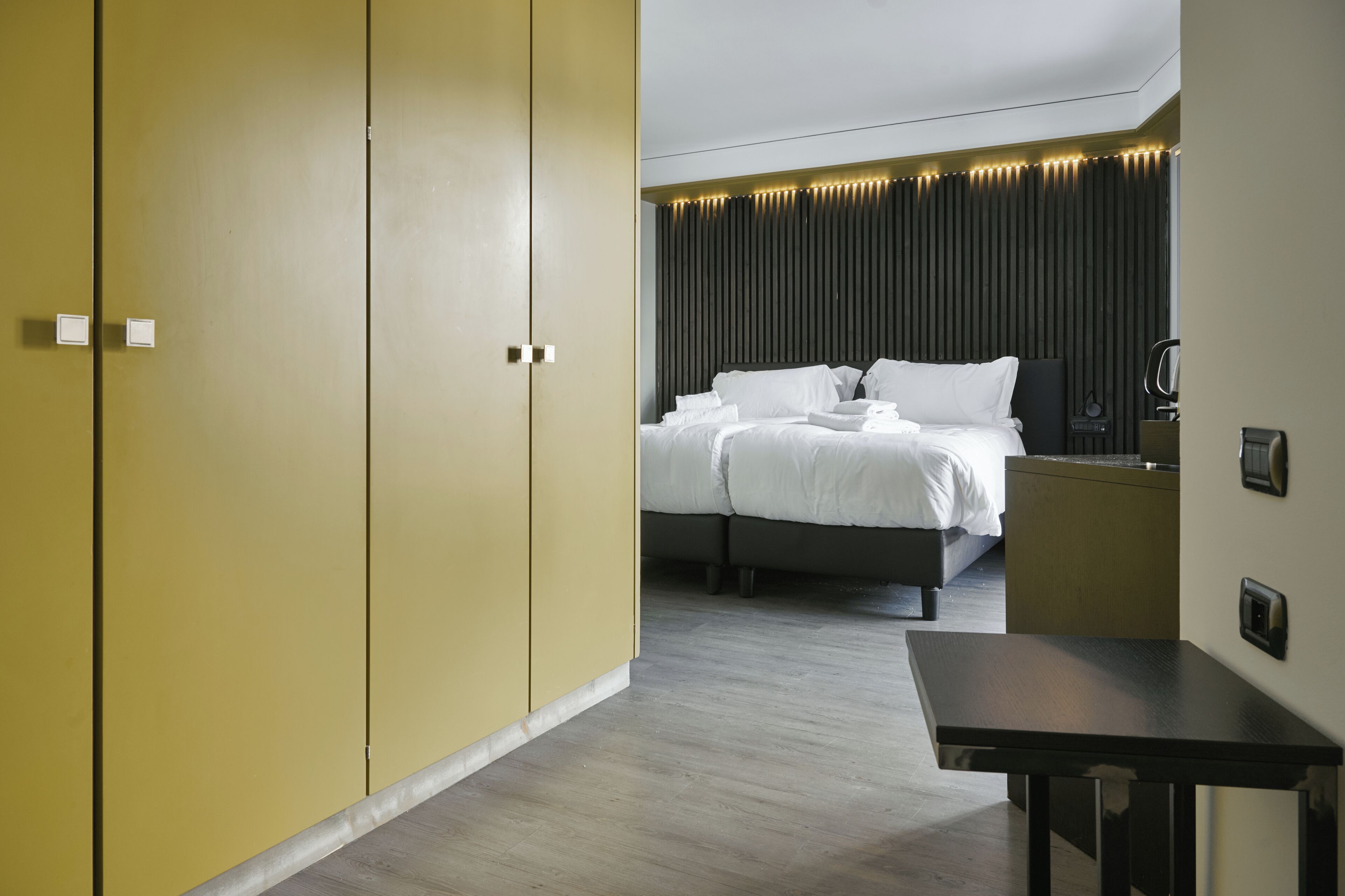 Une chambre d’hôtel avec un lit, une table de chevet et une armoire.