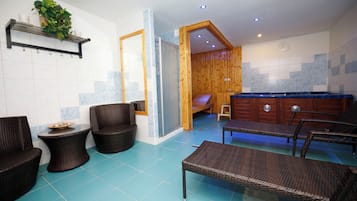 Relax in a serene space with a seating area, sofa, and massage table.