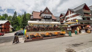 A hotel with outdoor seating, a Coca-Cola restaurant, and a sign for Jelinek Hotel. - Hotel Jelínek (Spindleruv Mlyn)