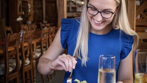 A person seated at a wooden table with a dessert and a glass of water. - Hotel Jelínek (Spindleruv Mlyn)