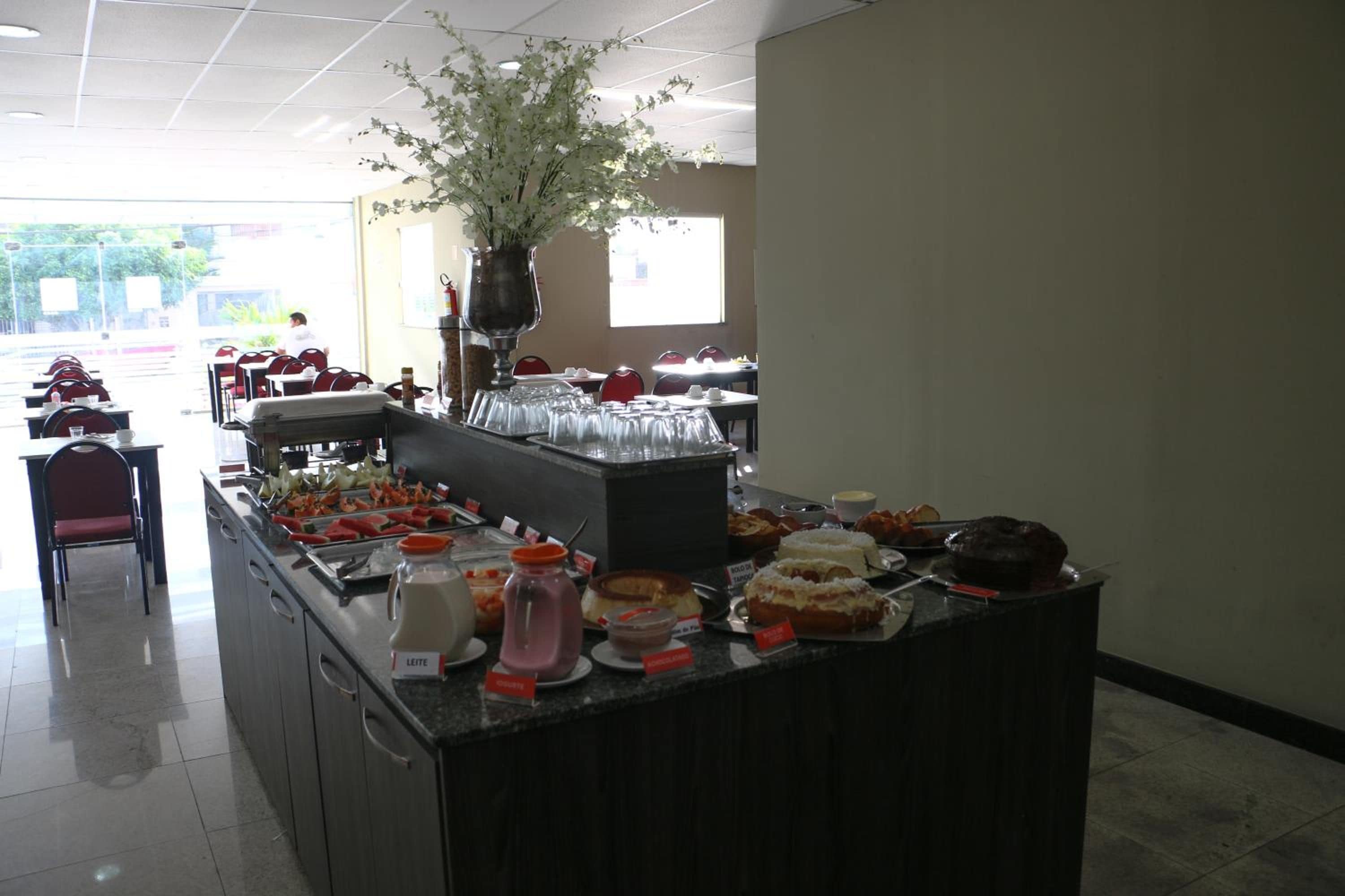 A buffet setup with various food items and a decorative plant.