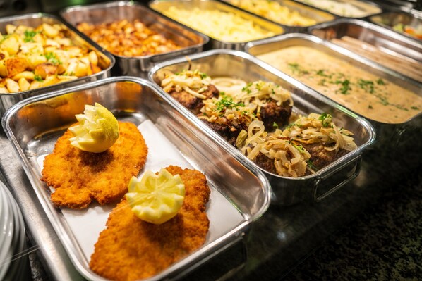 A buffet with various dishes including breaded cutlets, meatballs, and a creamy soup. - Serways Hotel Bruchsal West (Forst)