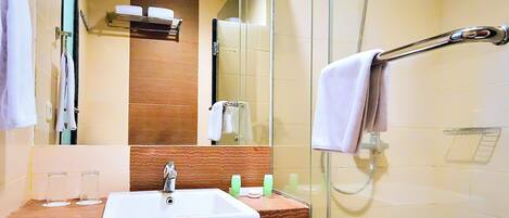 A modern bathroom with a glass-enclosed shower, a sink with a mirror above it, and a towel rack.