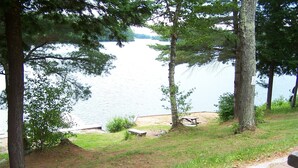 A lakeside view with trees, a picnic table, and a paved path. - H & H Restaurant and Resort (The Archipelago)