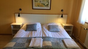 Un lit double avec deux oreillers, une couette et deux tables de chevet avec des lampes.