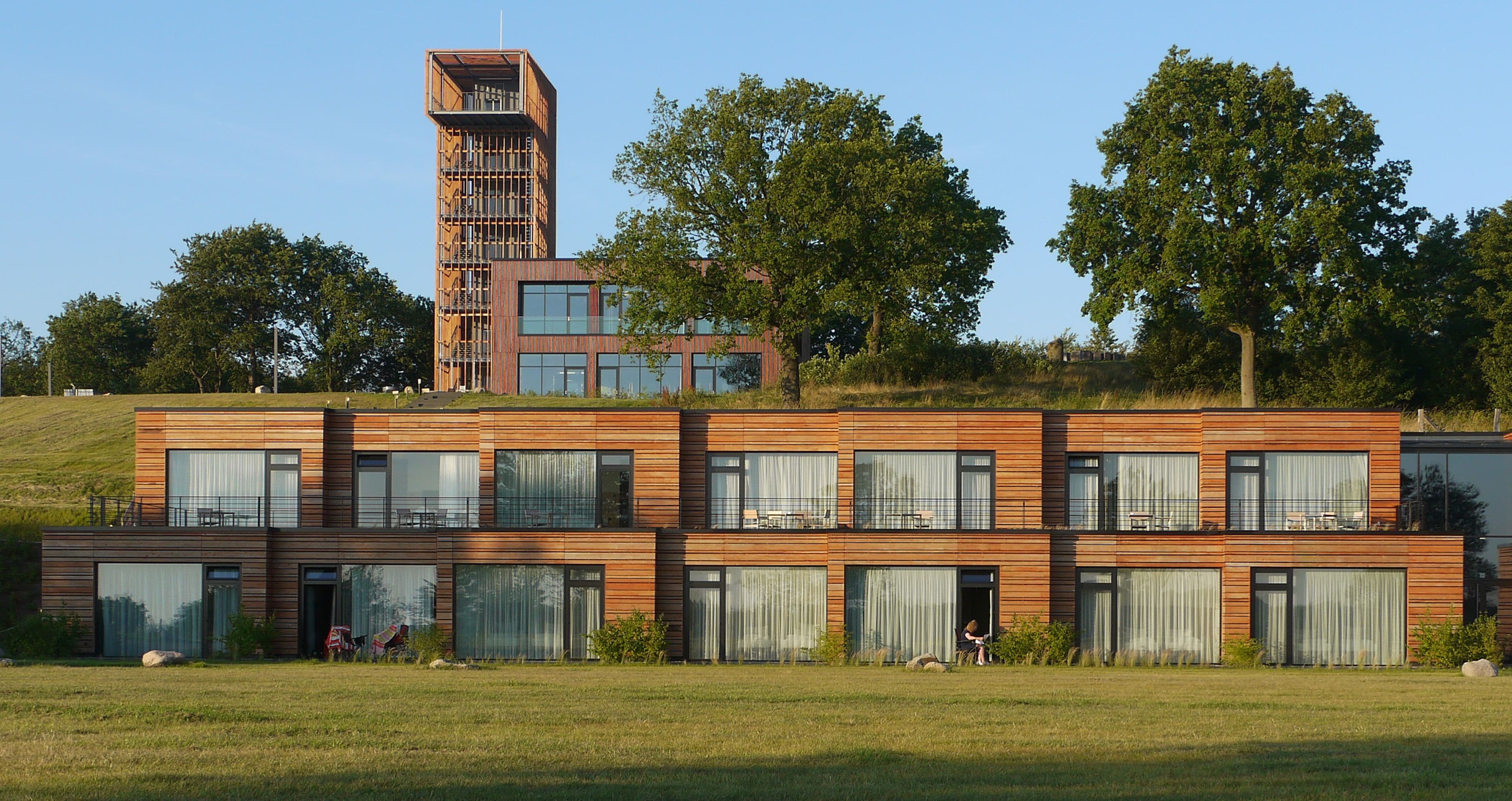 A modern multi-story building with large windows and a tower structure.