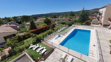 Alberca al aire libre por temporada y sombrillas en la alberca