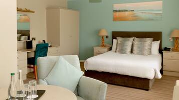 A hotel room with a bed, bedside lamps, a chair, a small table with glasses, and a wardrobe.