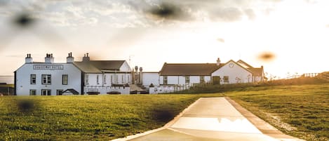 A hotel with a sign reading "CAUSEWAY HOTEL" in front of a row of buildings.
