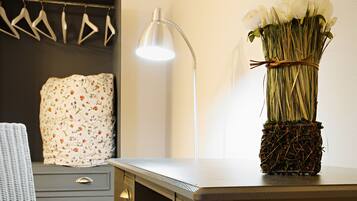 A modern room with a desk, chair, and a vase of flowers on the desk.